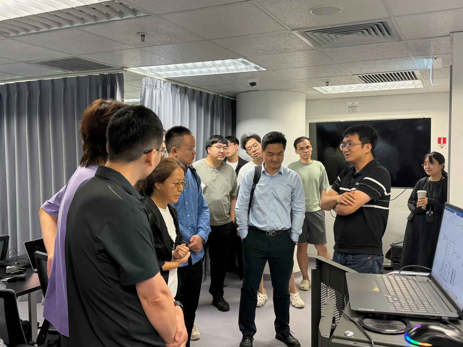 Watching Professor Yue Zhu talk with the visitors. I am in the olive-green T-shirt and black trousers, standing behind the person in the blue shirt.